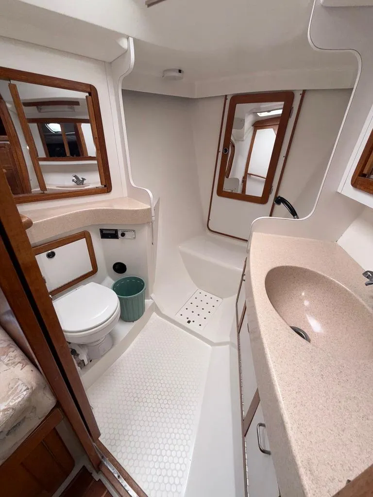 Slide: The Image of Bathroom interior of a 1998 Catalina 42Mk 2 yacht, featuring sink, toilet, and shower. - 16