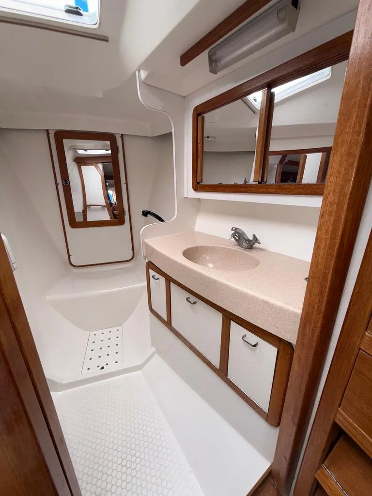 Slide: The Image of Interior of 1998 Catalina 42Mk 2 yacht bathroom with sink, mirror, and wooden accents. - 17