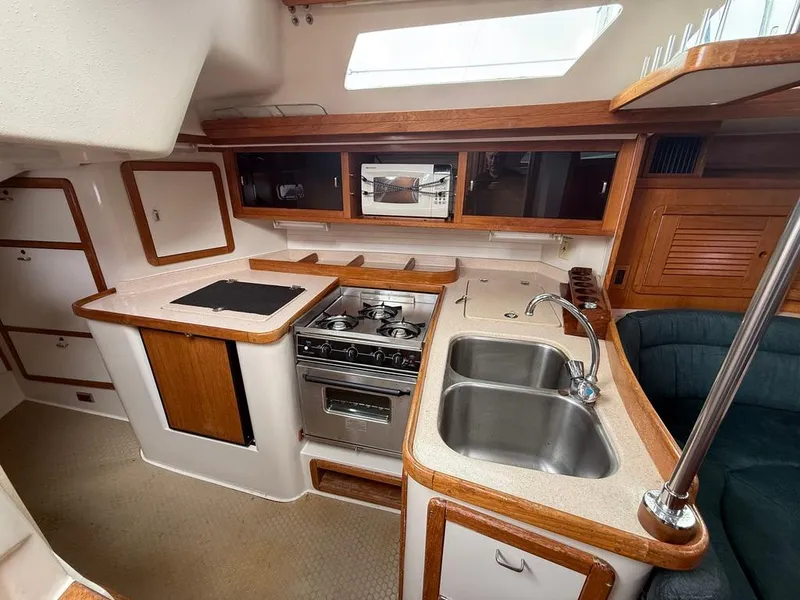 Slide: The Image of Interior of 1998 Catalina 42Mk 2 yacht kitchen with stove, sink, and wooden cabinetry. - 5