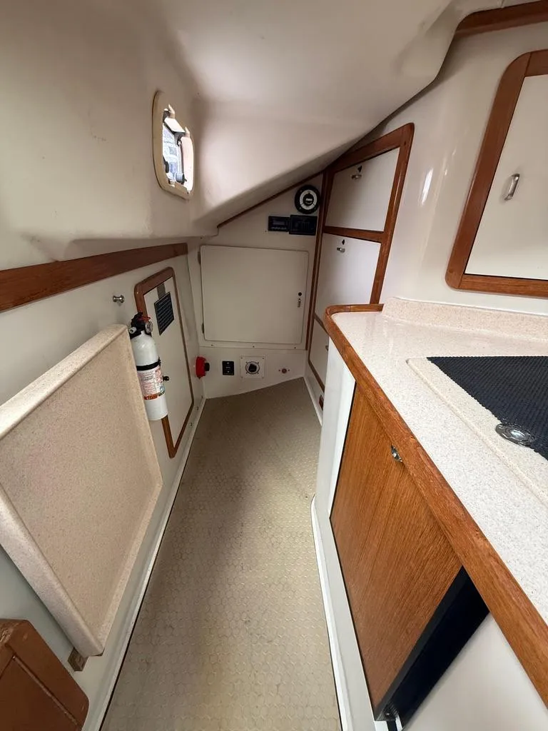 Slide: The Image of Interior of 1998 Catalina 42Mk 2 sailboat, featuring compact kitchen and storage area. - 7