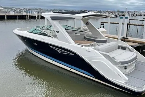 The Image of 2021 Sea Ray SLX 310 boat docked in marina, featuring sleek design and spacious seating. - 1