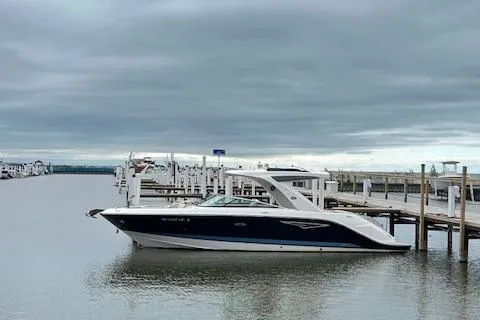 Slide: The Image of 2021 Sea Ray SLX 310 boat docked at a marina under cloudy skies. - 3