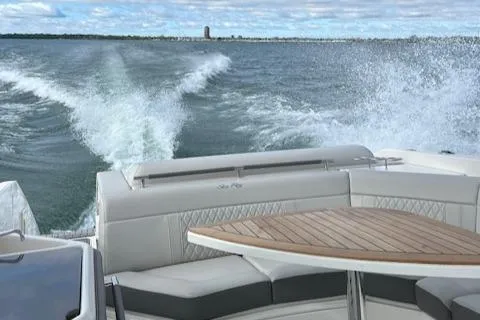 Slide: The Image of 2021 Sea Ray SLX 310 cruising on open water, view from rear seating area. - 6