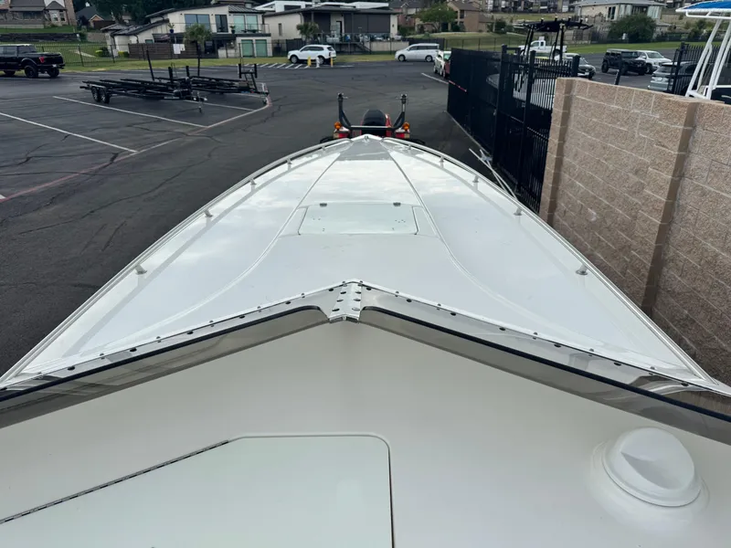 Slide: The Image of 2004 Fountain 35 Executioner boat parked in a marina with trailers and vehicles nearby. - 4