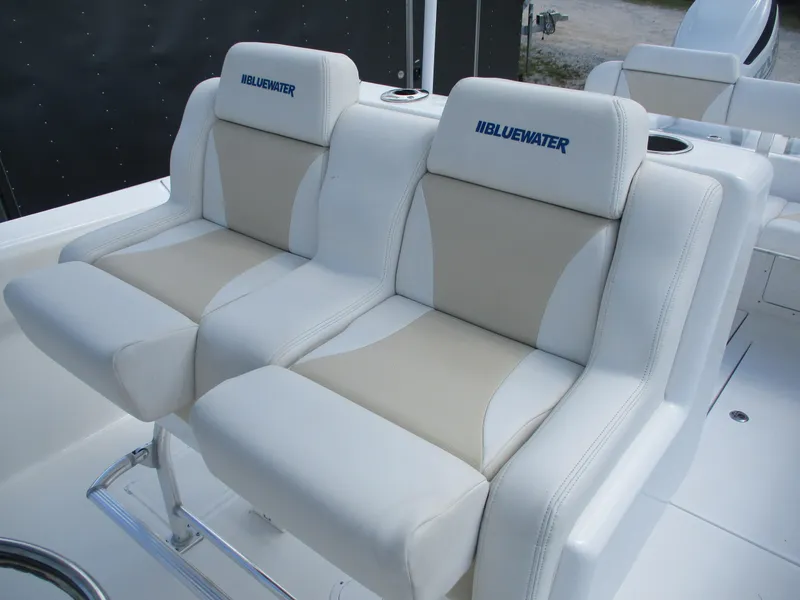 Slide: The Image of 2024 Bluewater 2850 boat seats, white and beige upholstery, dual seating arrangement. - 14