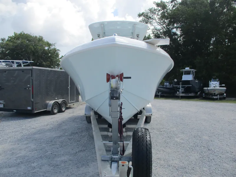 Slide: The Image of 2024 Bluewater 2850 boat on trailer, parked outdoors with trees in background. - 3