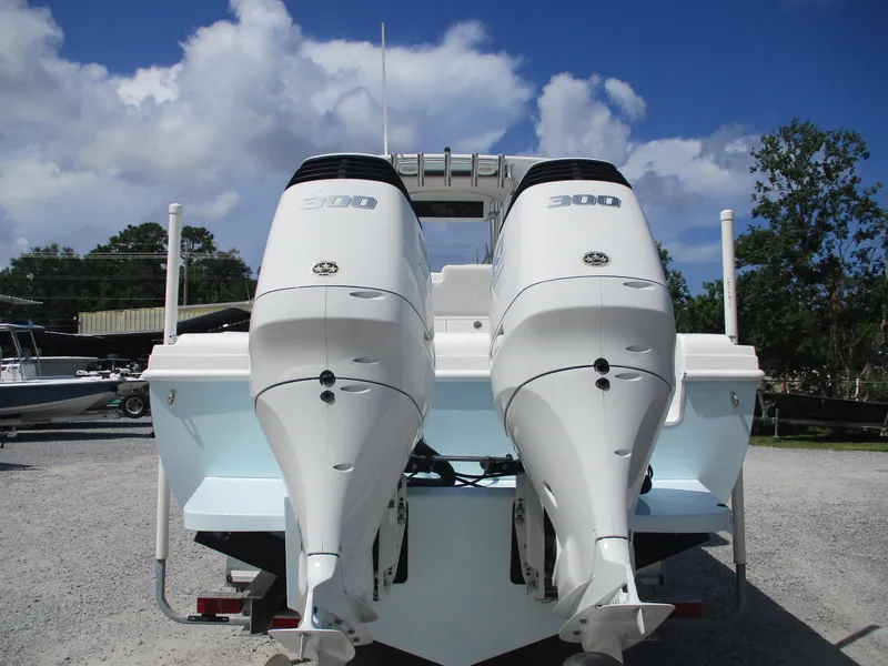Slide: The Image of 2024 Bluewater 2850 boat with dual 300 horsepower engines, parked outdoors under a blue sky. - 9