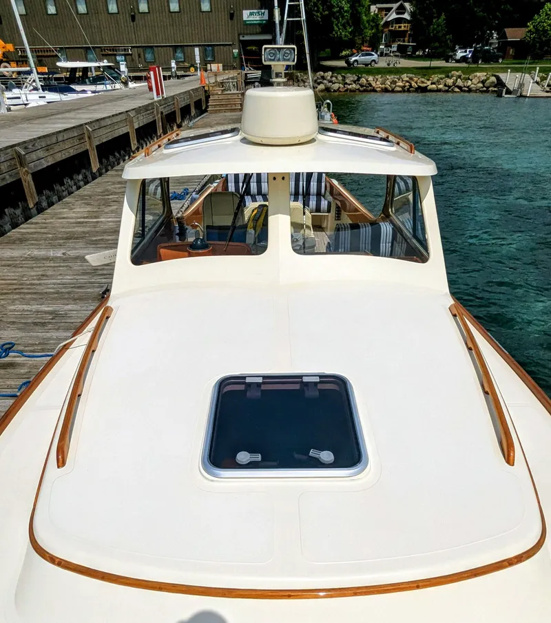 Slide: The Image of 2000 Hinckley Picnic Boat docked by a wooden pier, showcasing its sleek design and craftsmanship. - 14