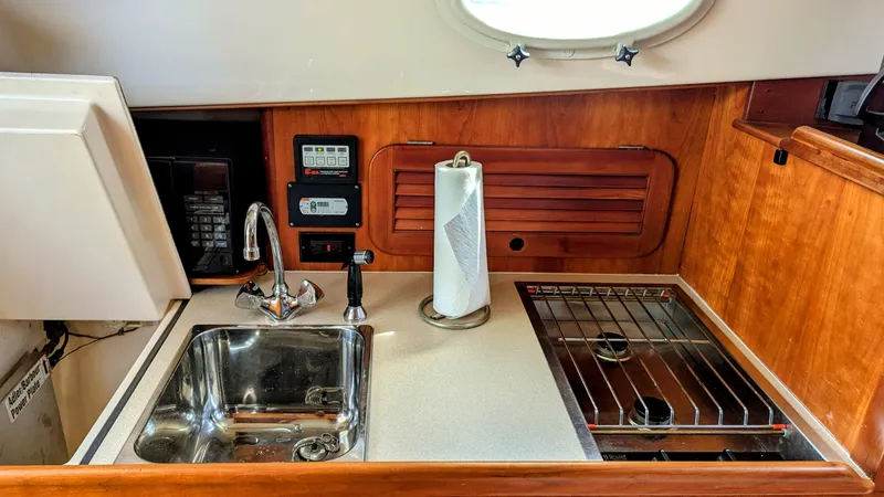 Slide: The Image of Compact galley in 2000 Hinckley Picnic Boat with sink, stove, and paper towel holder. - 8