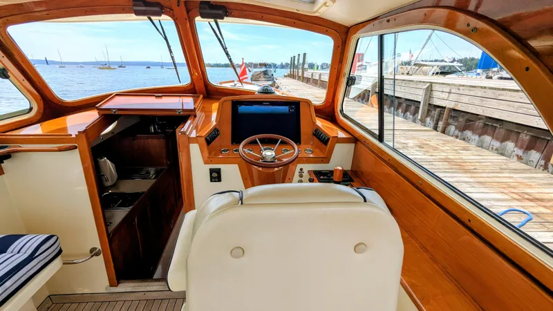 Slide: The Image of Interior of a 2000 Hinckley Picnic Boat with wooden accents and a view of the dock. - 4