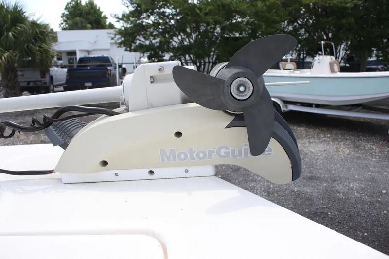 Slide: The Image of MotorGuide trolling motor on 2022 Sundance DX22 boat, parked outdoors. - 11