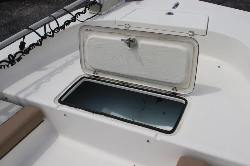 Slide: The Image of Open storage compartment on 2022 Sundance DX22 boat, showcasing interior space. - 12