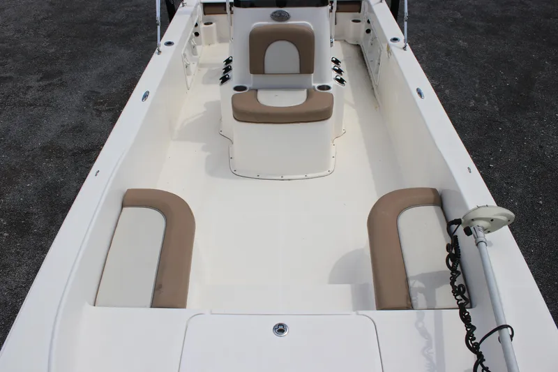 Slide: The Image of 2022 Sundance DX22 boat interior with beige seating and white deck. - 14