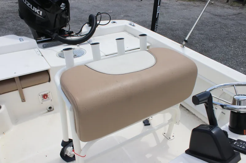 Slide: The Image of 2022 Sundance DX22 boat interior with beige seating and Suzuki motor. - 15