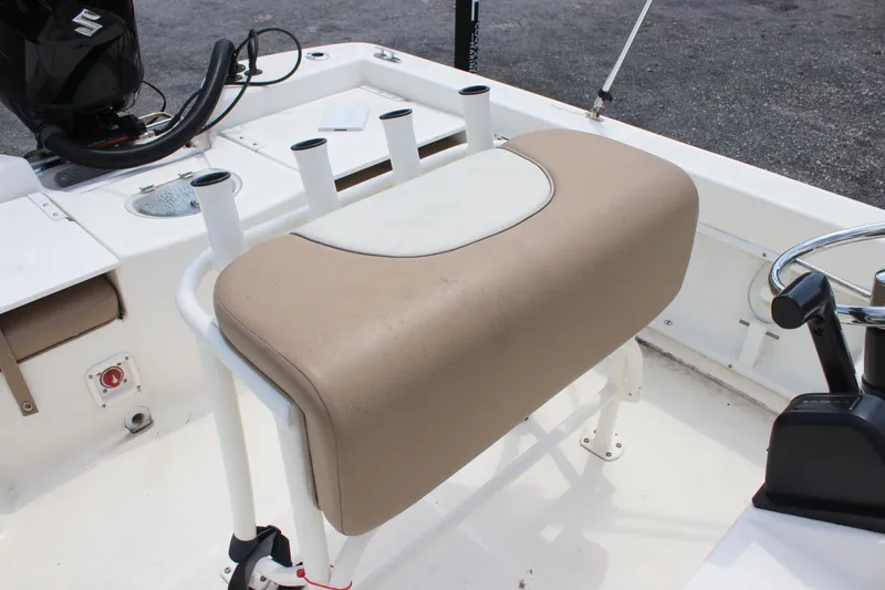 Slide: The Image of 2022 Sundance DX22 boat interior with tan seating and fishing rod holders. - 17