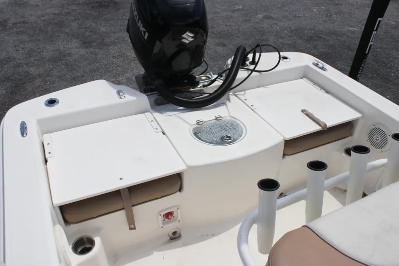 Slide: The Image of 2022 Sundance DX22 boat stern with Suzuki outboard motor and storage compartments. - 19