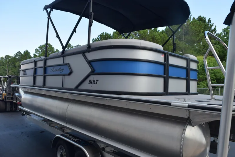 Slide: The Image of 2026 Bentley Pontoons Bolt on trailer, featuring sleek design and blue accents. - 6