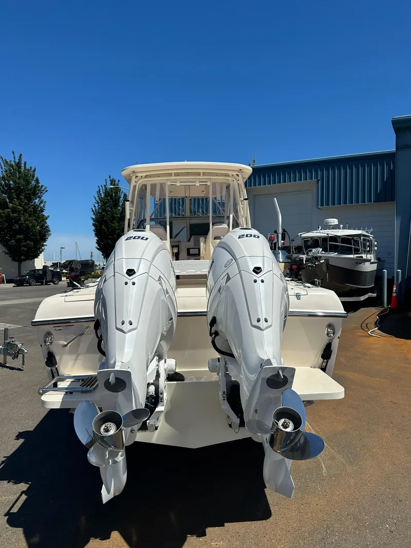 Slide: The Image of 2024 Grady-White 232 Gulfstream boat with dual outboard engines, docked outdoors. - 10