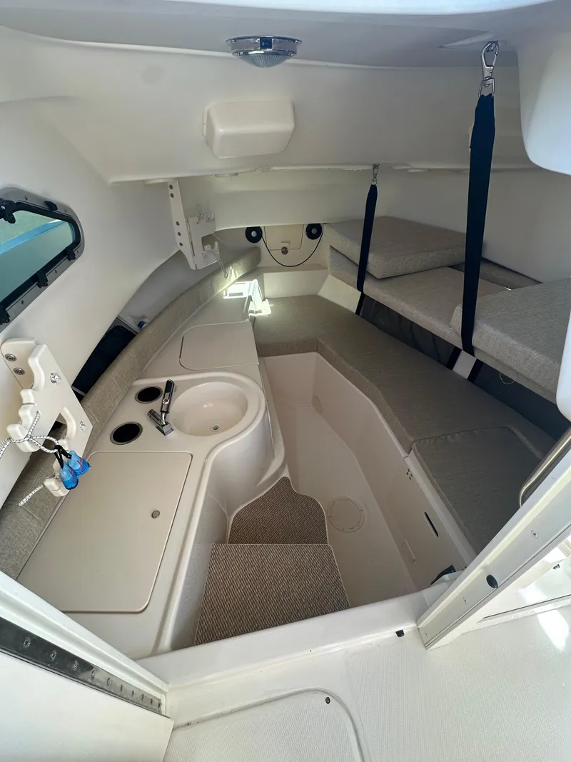 Slide: The Image of 2024 Grady-White 232 Gulfstream cabin interior with sink, seating, and storage. - 5
