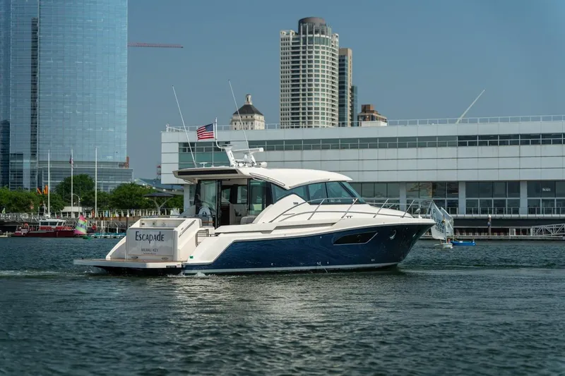 Slide: The Image of 2017 Tiara Yachts C44 Coupe cruising near urban waterfront buildings. - 10