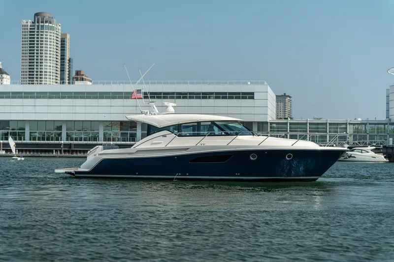 Slide: The Image of 2017 Tiara Yachts C44 Coupe in marina, cityscape background. - 12