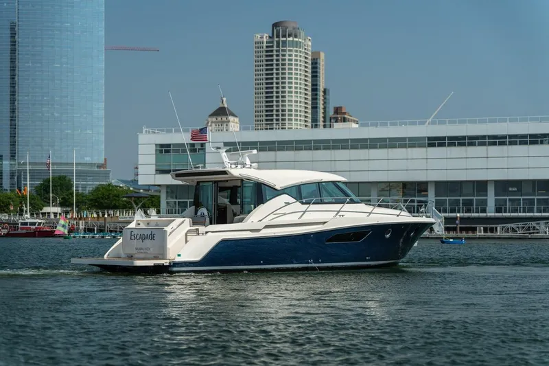 Slide: The Image of 2017 Tiara Yachts C44 Coupe cruising near city waterfront buildings. - 13