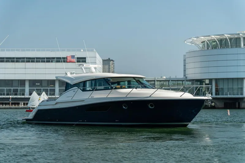 Slide: The Image of 2017 Tiara Yachts C44 Coupe in marina, modern architecture background. - 22