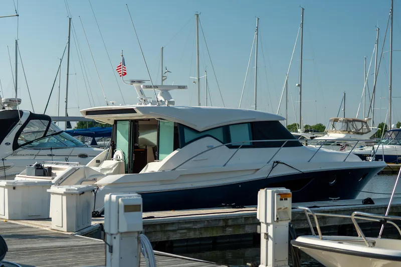 Slide: The Image of 2017 Tiara Yachts C44 Coupe docked at marina with sailboats in background. - 34