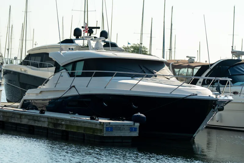 Slide: The Image of 2017 Tiara Yachts C44 Coupe docked at marina, surrounded by other boats. - 35