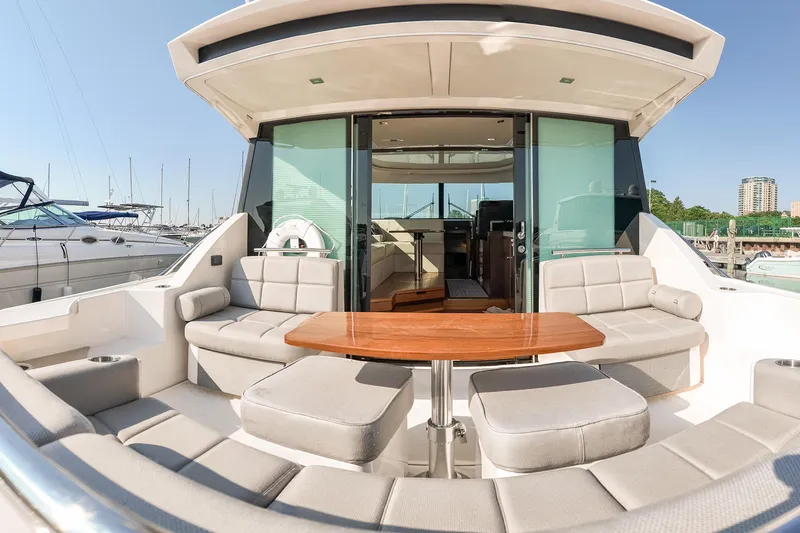 Slide: The Image of 2017 Tiara Yachts C44 Coupe with spacious outdoor seating and elegant wooden table. - 42