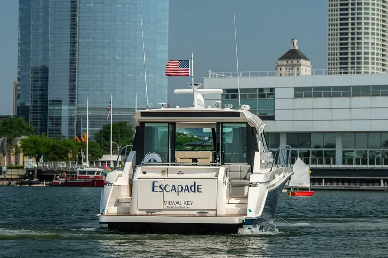 Slide: The Image of 2017 Tiara Yachts C44 Coupe "Escapade" cruising near city waterfront. - 5