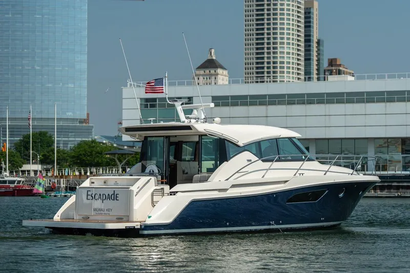 Slide: The Image of 2017 Tiara Yachts C44 Coupe cruising near urban waterfront with skyscrapers in background. - 7
