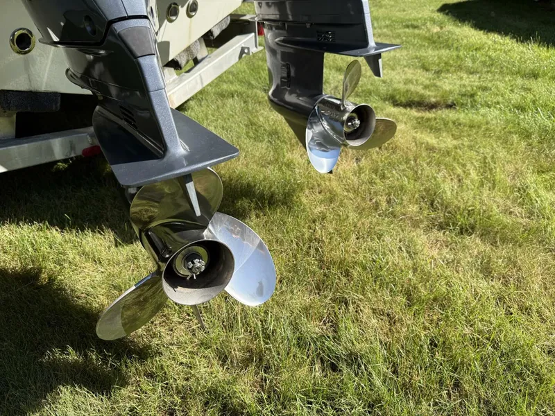 Slide: The Image of 2023 Key West 263 FS boat propellers on grass, showcasing dual outboard motors. - 10