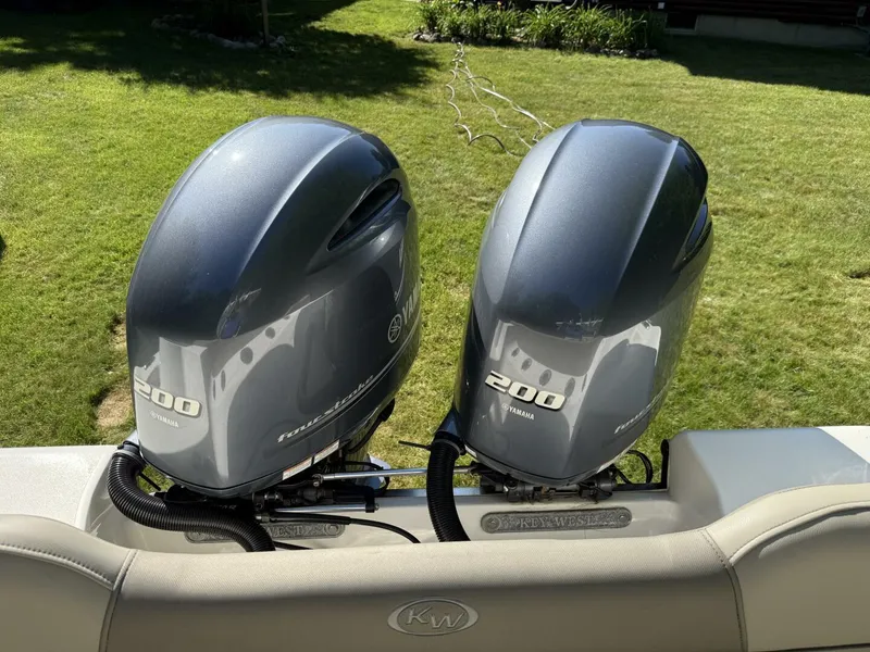 Slide: The Image of Twin Yamaha 200 engines on a 2023 Key West 263 FS boat, parked on grass. - 11