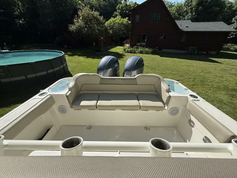 Slide: The Image of 2023 Key West 263 FS boat with dual engines, parked in a grassy backyard near a pool. - 12