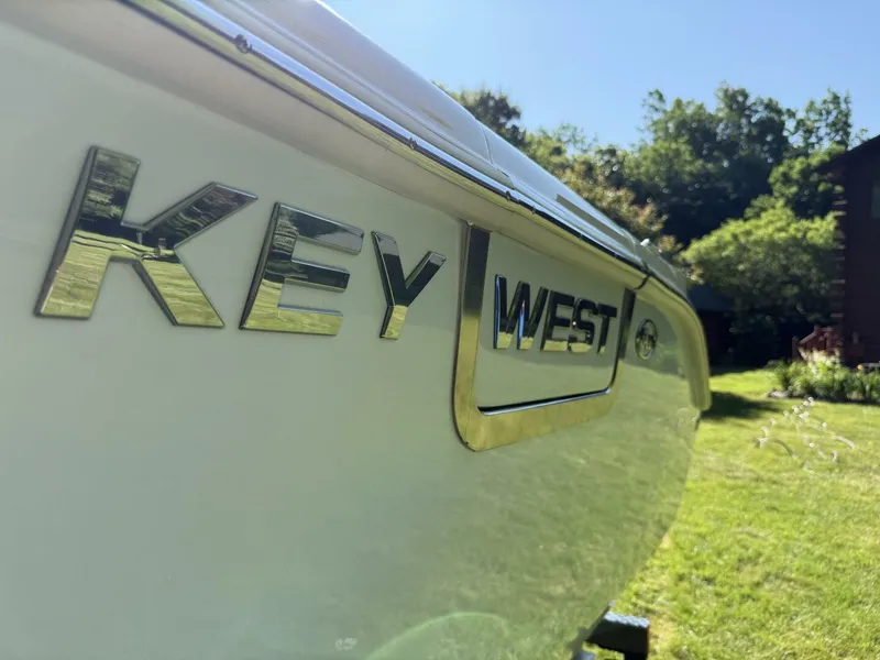 Slide: The Image of 2023 Key West 263 FS boat side view with logo, outdoors in sunny setting. - 6