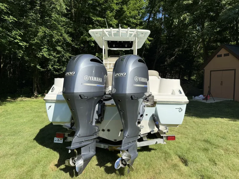 Slide: The Image of 2023 Key West 263 FS boat with dual Yamaha 200 engines, parked on grass. - 9