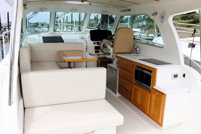 Slide: The Image of 2020 Back Cove 34O yacht interior with seating, table, and kitchenette. - 10