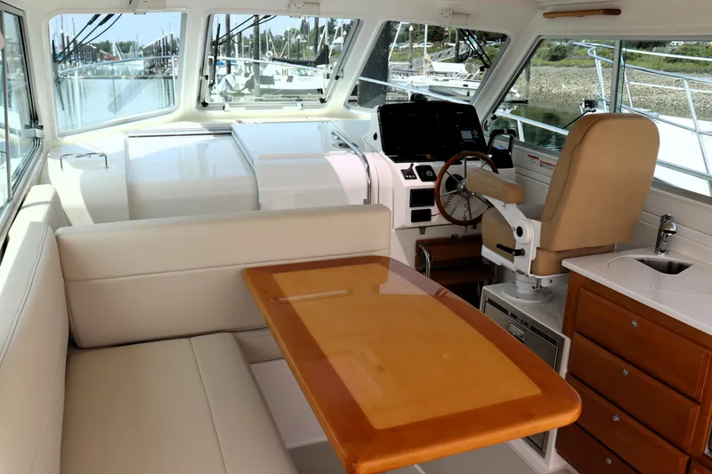 Slide: The Image of Interior of 2020 Back Cove 34O yacht with helm, seating, and wooden table. - 16