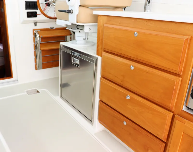 Slide: The Image of 2020 Back Cove 34O interior with wooden cabinetry and stainless steel appliances. - 17