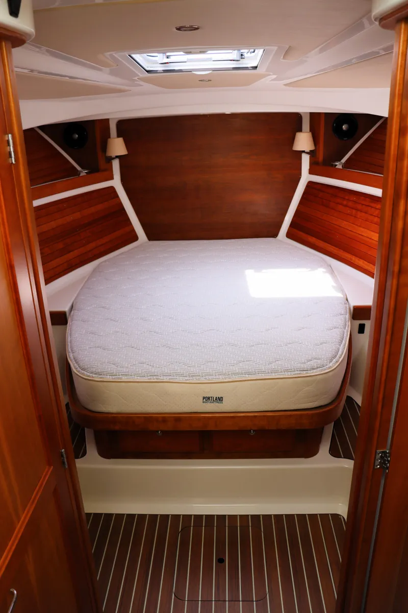 Slide: The Image of 2020 Back Cove 34O cabin interior with wooden finish and cozy bed. - 19
