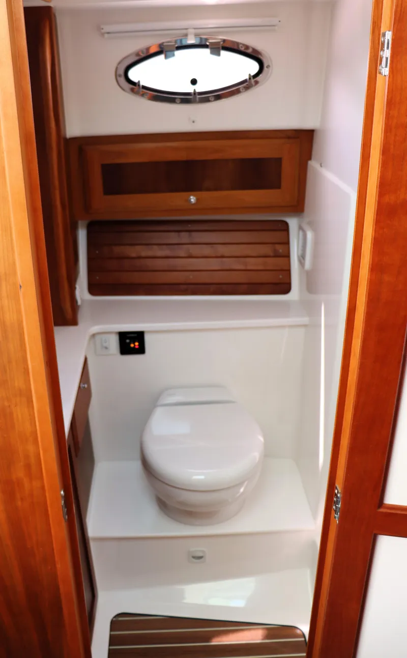 Slide: The Image of 2020 Back Cove 34O yacht bathroom with wooden cabinetry and porthole window. - 22