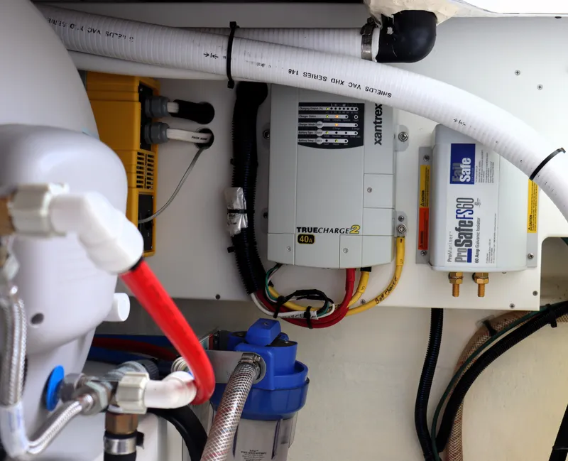 Slide: The Image of Electrical components in a 2020 Back Cove 34O boat, featuring chargers and wiring. - 30