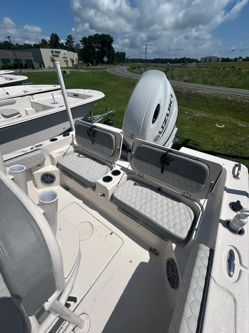 Slide: The Image of 2025 Carolina Skiff 21 Ultra Elite boat interior with Suzuki outboard motor, featuring cushioned seating. - 5