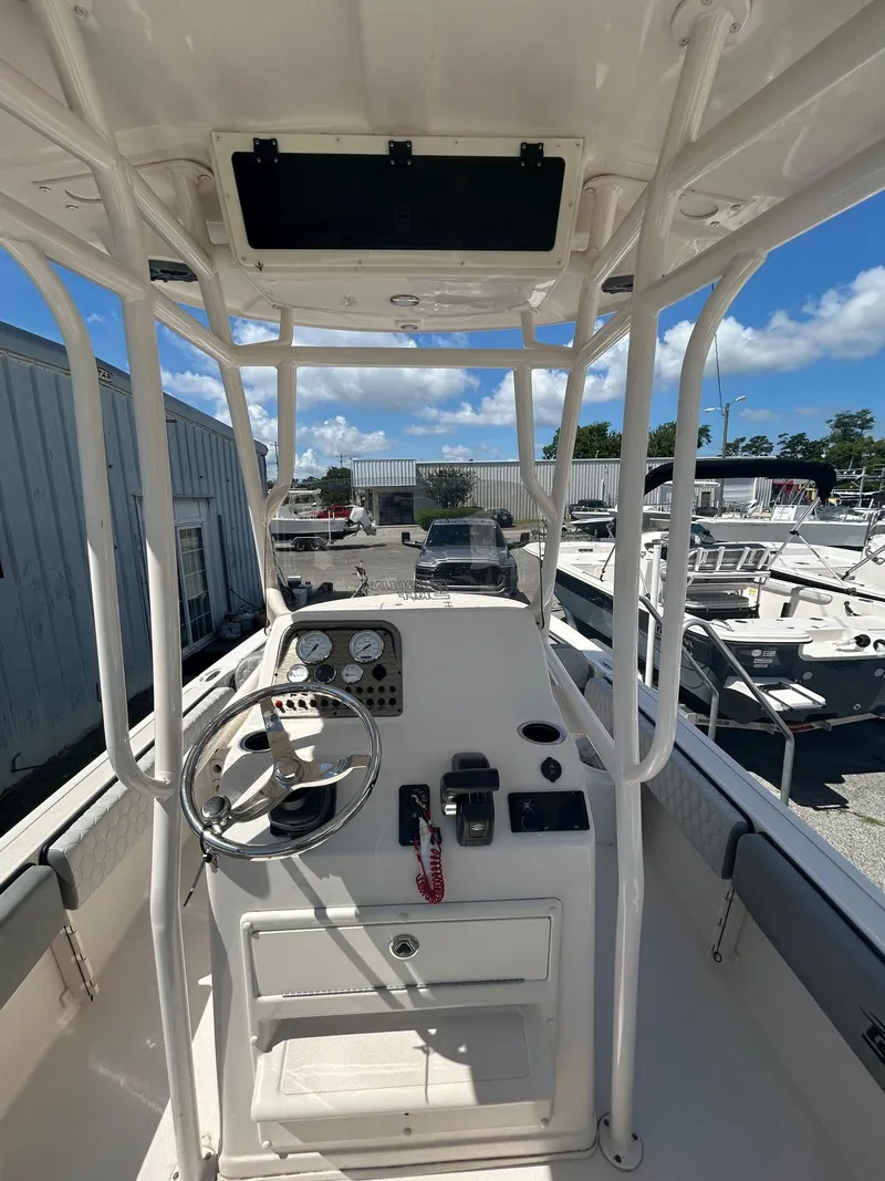 Slide: The Image of 2025 Carolina Skiff 21 Ultra Elite boat console with steering wheel and gauges, docked outdoors. - 8