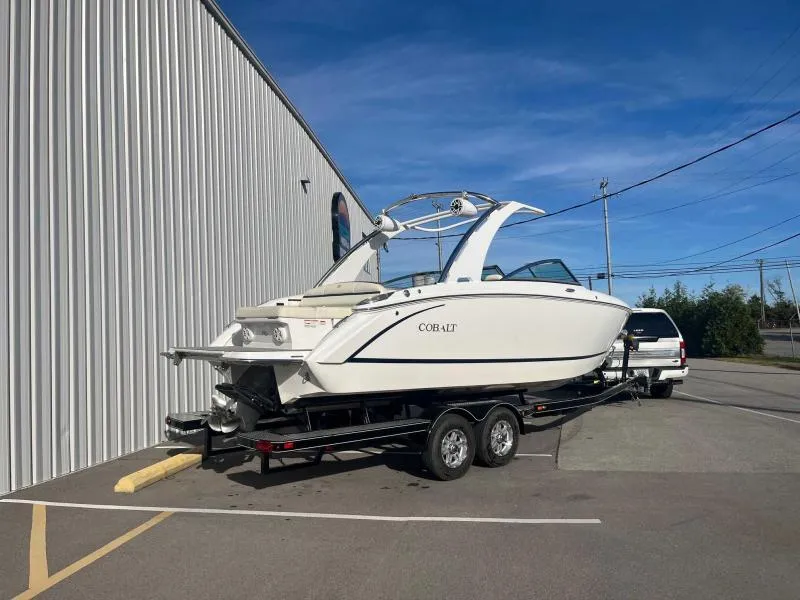 Slide: The Image of 2021 Cobalt R7 boat on trailer, parked beside a building under clear blue sky. - 3
