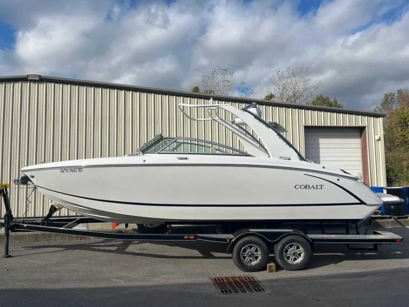 Slide: The Image of 2021 Cobalt R7 boat on trailer, parked outside a warehouse under cloudy sky. - 7