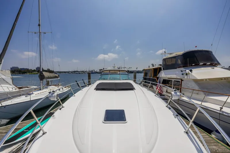 Slide: The Image of Sea Ray 510 Sundancer 2000 yacht docked at marina under clear blue sky. - 10