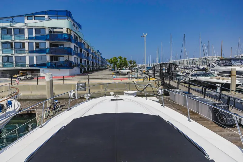 Slide: The Image of 2000 Sea Ray 510 Sundancer docked at marina with modern buildings and clear blue sky. - 14