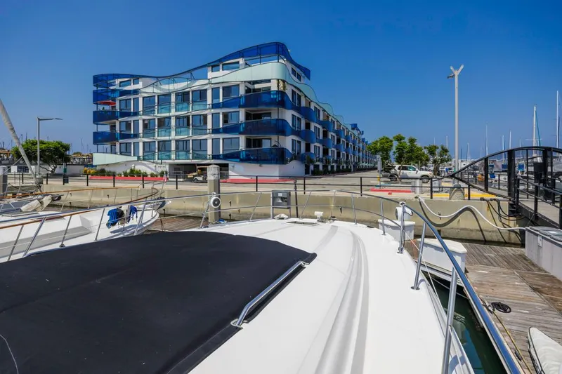 Slide: The Image of Sea Ray 510 Sundancer yacht docked near modern waterfront building, clear blue sky. - 16